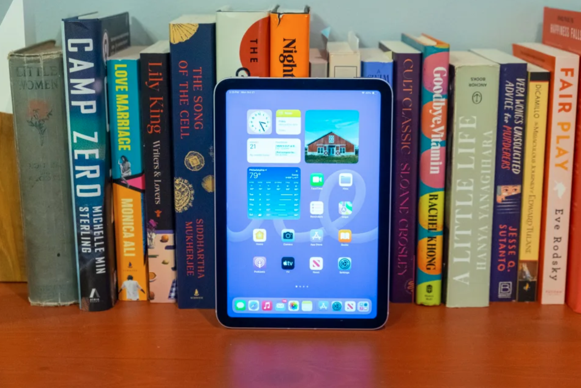 A tablet resting against books.
