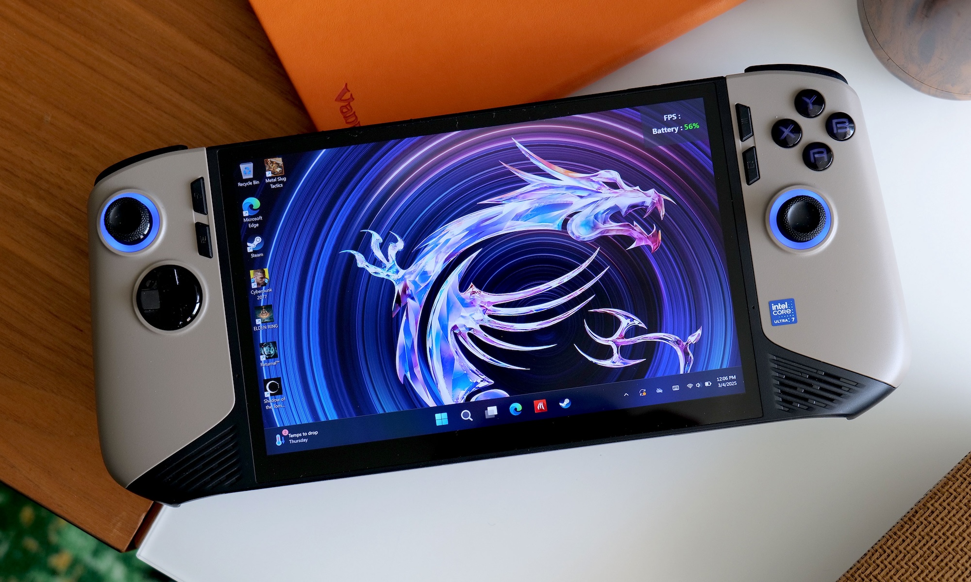 The beige-and-black MSI Claw 8 AI+ gaming handheld rests on a brown and white table with its screen active and facing the camera.